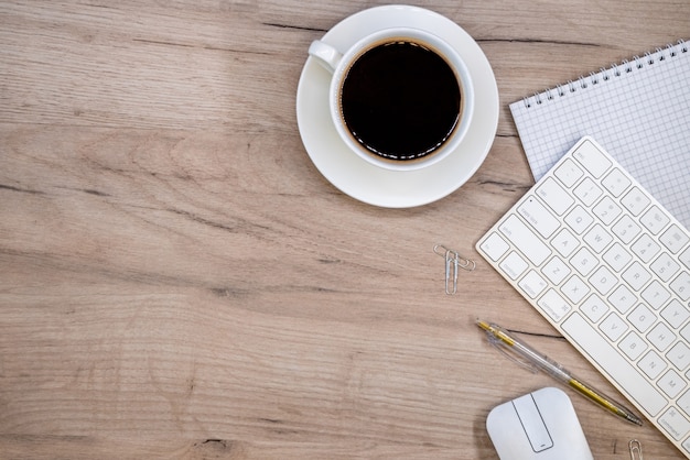 Arbeitsbereich mit Büromaterial und Kaffeetasse