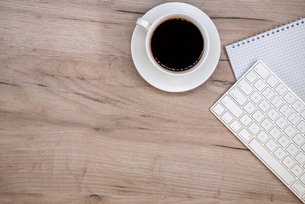 Arbeitsbereich mit Büromaterial und Kaffeetasse