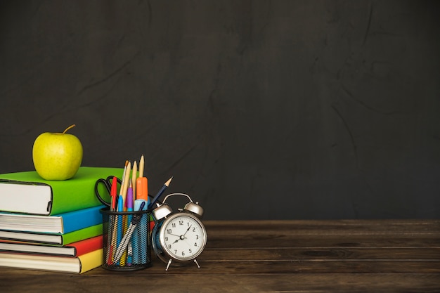 Arbeitsplatz mit Lehrbüchern Briefpapier und Wecker