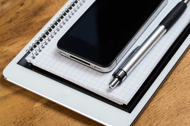 Arbeitsplatz. Telefon, Tablet und Notizblock auf dem Tisch