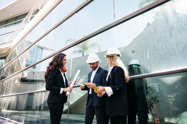 Architekten tragen Helme und Pläne