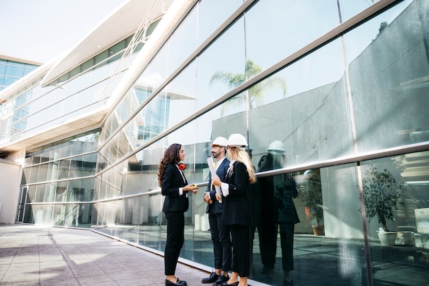 Architekten tragen Helme vor Gebäude