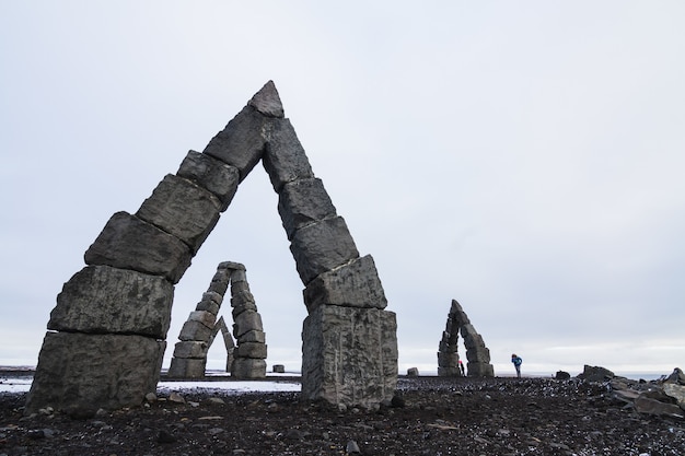 Kostenloses Foto arctic henge, umgeben von einem schneebedeckten feld unter einem bewölkten himmel in island