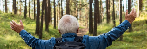 Kostenloses Foto arme weit offener älterer mann, der natur erforscht