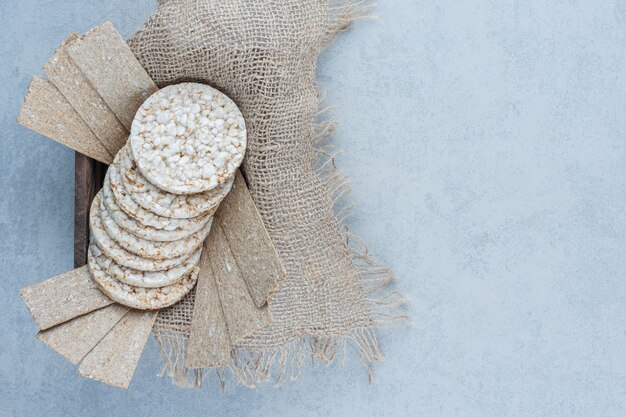 Aromatische Knäckebrote auf Handtuch in der Schachtel auf Marmor.