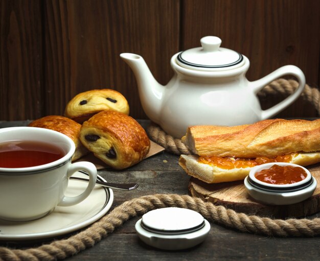 Aromatisierter Tee und ein Butterbrot mit Marmelade