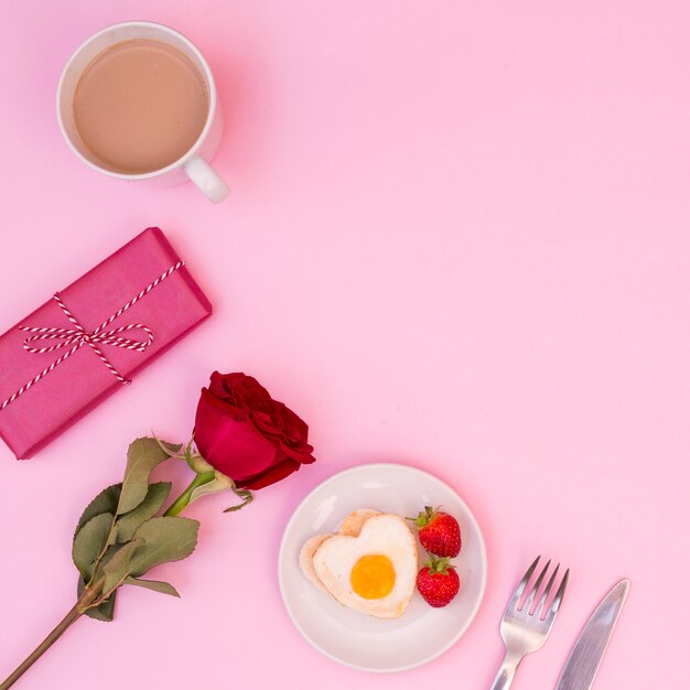 Arrangement für ein romantisches Frühstück mit Rose und Geschenk