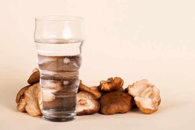 Arrangement mit einem Glas Wasser und Champignons