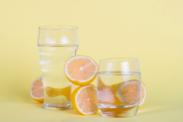 Arrangement mit Gläsern Wasser und Zitronen