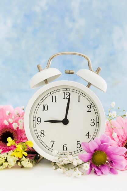 Arrangement mit Uhr und bunten Blumen