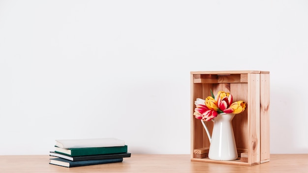 Arrangierte Blumen in Box und Notizbüchern