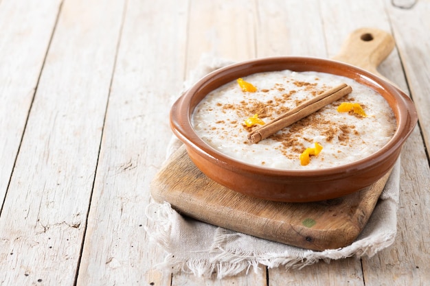 Kostenloses Foto arroz con leche reispudding mit zimt in einer tonschüssel auf einem holztisch