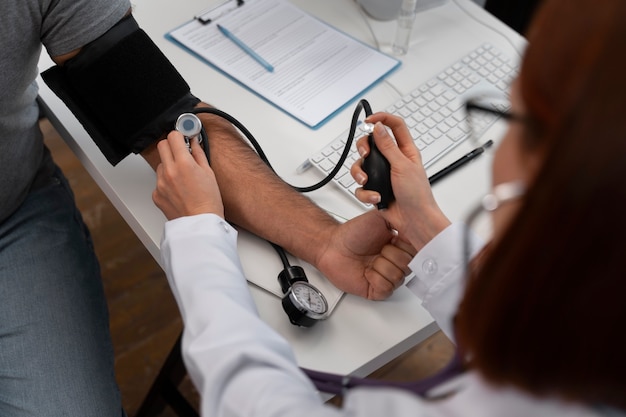 Kostenloses Foto arzt aus dem hohen winkel, der den patienten überprüft