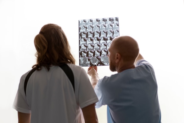 Kostenloses Foto arzt der rückansicht, der die radiographie erklärt