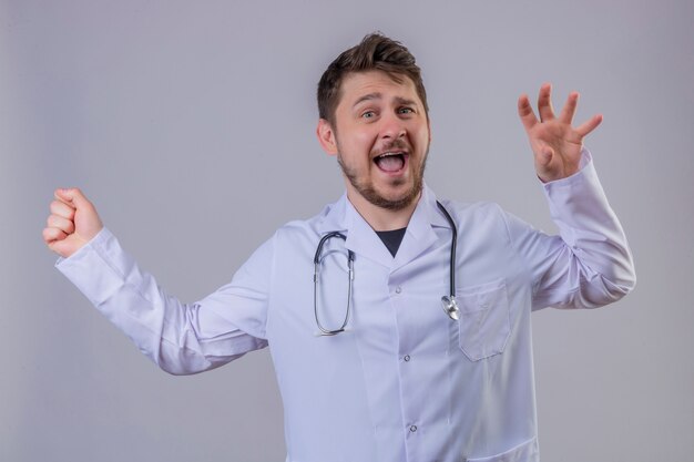 Arzt des jungen Mannes, der weißen Kittel und Stethoskop trägt, überrascht mit glücklichem Gesicht 1