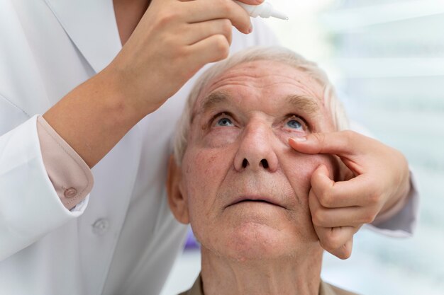 Arzt gießt einem Patienten Augentropfen ein