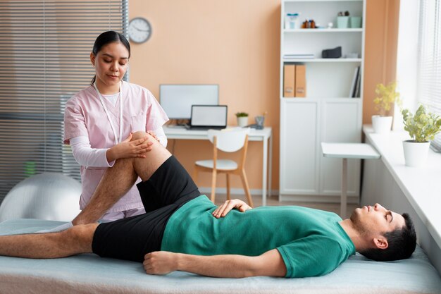 Arzt hilft Patienten während der Rehabilitation