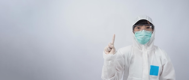 Arzt im psa-anzug mit weißen medizinischen gummihandschuhen und durchsichtiger schutzbrille und grüner n95-gesichtsmaske zum schutz der pandemischen coronavirus-geste machen handzeichen repräsentieren den sieg über das isolierte virus Premium Fotos