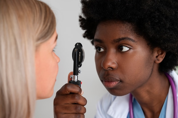 Kostenloses Foto arzt mit seitenansicht, der die augen des patienten überprüft