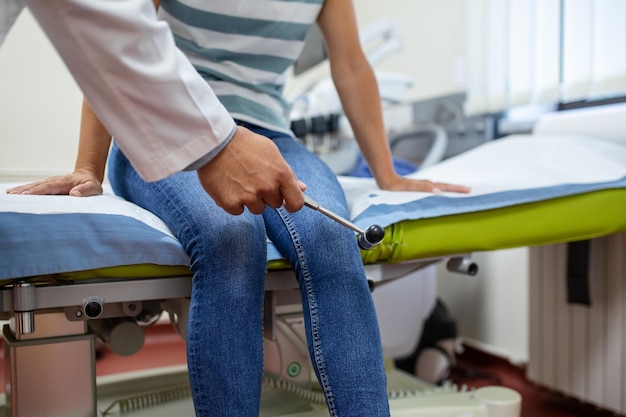 Kostenloses Foto arzt neurologe klopft mit hammer in der klinik nahaufnahme auf das knie des patienten diagnose der neurologischen pathologie des kniereflexkonzepts