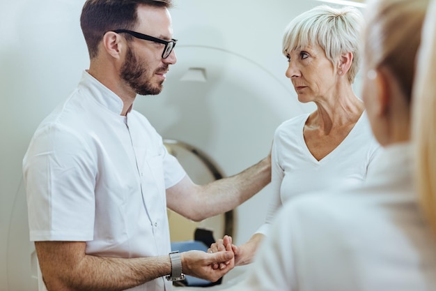 Arzt tröstet seinen besorgten reifen Patienten vor dem MRT-Scan-Verfahren im Krankenhaus