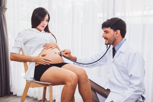 Arzt überprüft schwangere Frau mit Stethoskop im Krankenhaus-Gesundheitskonzept