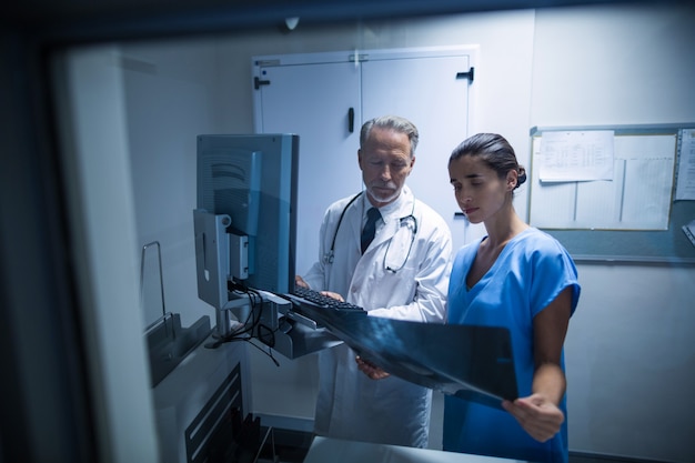 Kostenloses Foto arzt und krankenschwester untersuchen eine röntgenaufnahme