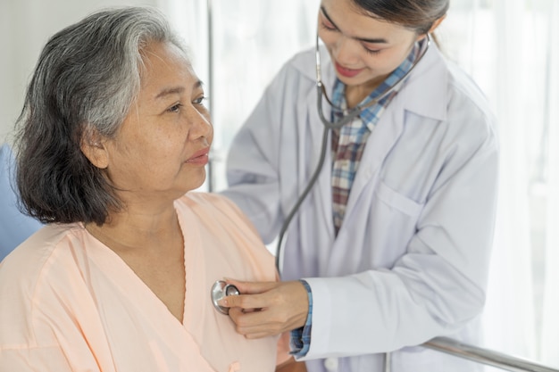 Arzt untersucht ältere ältere Patientin im Krankenhausbett Patienten - medizinisches und medizinisches Seniorenkonzept