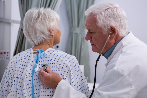 Arzt untersucht älteren patienten mit stethoskop
