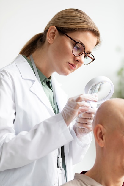 Kostenloses Foto arzt untersucht einen patienten mit hautkrebs