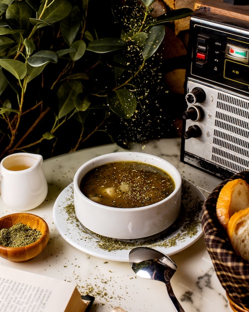 Aserbaidschanische Dushbara-Knödelsuppe, garniert mit getrockneten Minzblättern