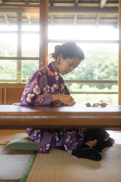 Asiatin macht Origami mit Japanpapier