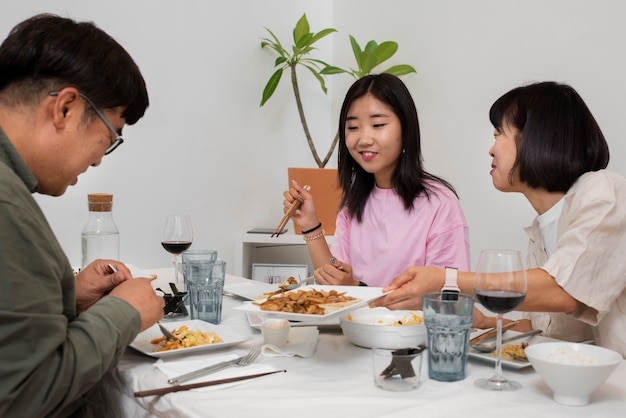 Asiatische familie des mittleren schusses, die zusammen isst