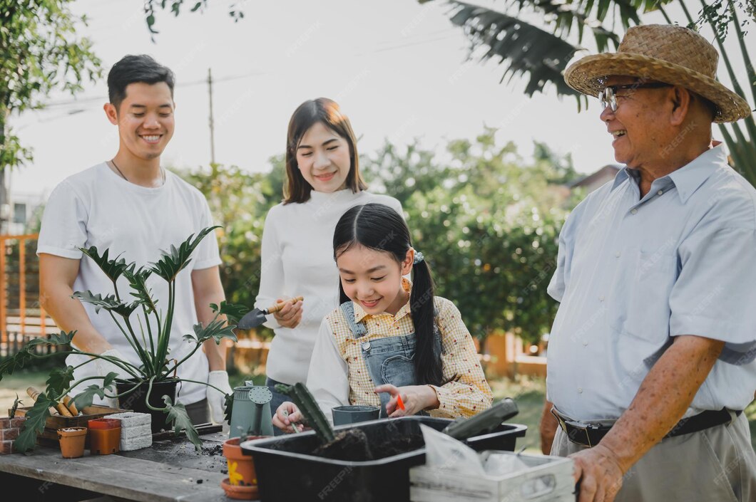 Asiatische familie, die zu hause baum im garten pflanzt
