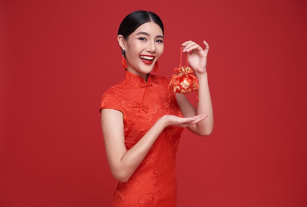 Kostenloses Foto asiatische frau des glücklichen chinesischen neuen jahres, die angpao oder geldgeschenk des roten pakets und roten geldbeutel hält