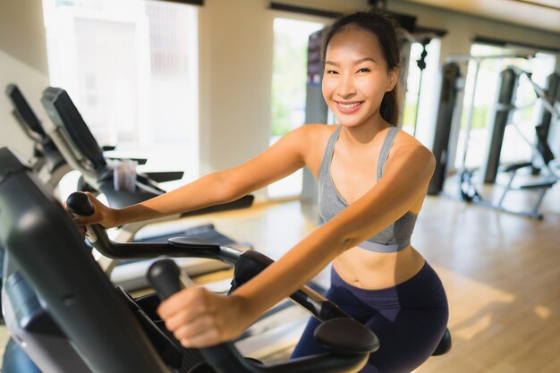 Asiatische Frau des Porträts, die trainiert und in der Turnhalle ausarbeitet