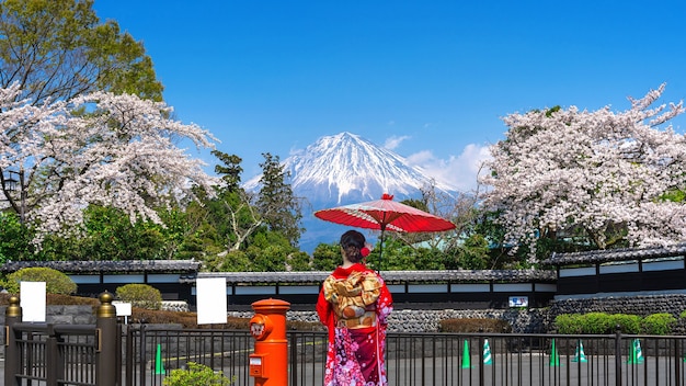 Asiatische Frau, die den traditionellen japanischen Kimono am Fuji-Berg und an der Kirschblüte im Frühjahr Fujinomiya in Japan trägt.