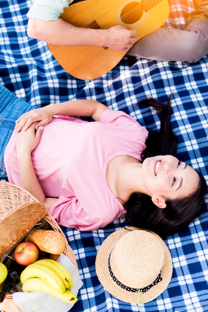 Asiatische Frau, die Gitarre hört