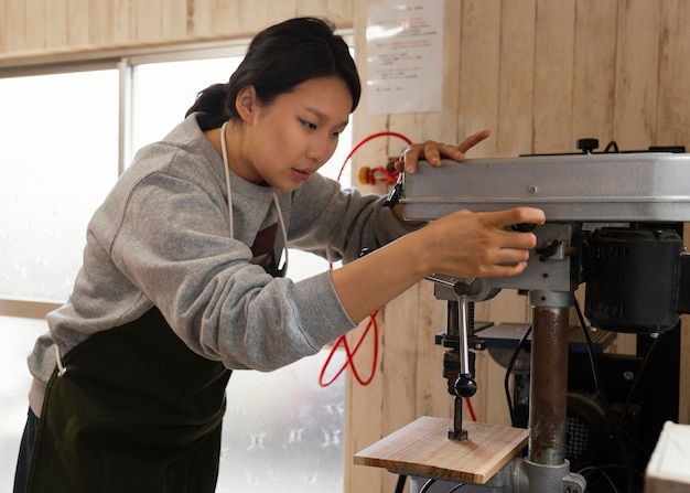 Asiatische Frau, die mit Holz arbeitet