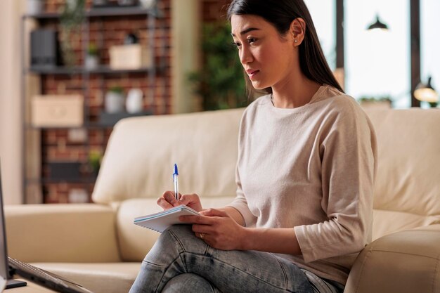 Asiatische Frau, die sich Notizen im Fernstudium macht, Online-Schulungskurse, Webinar für Studenten, Bildung, Heimbüro, intelligente Universität, Bewerbungschat, Gesprächstraining, Fernstudium, Arbeit von zu Hause aus