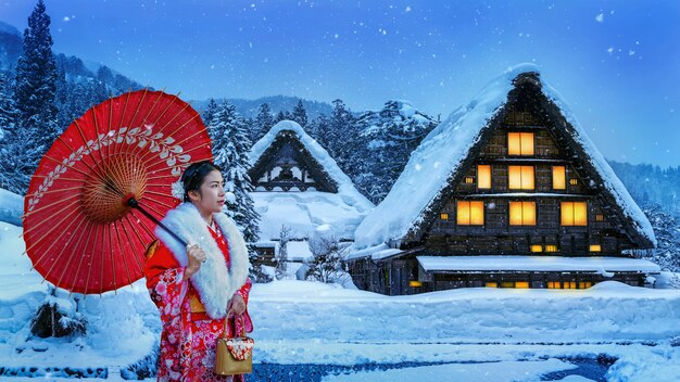 Asiatische Frau, die traditionellen japanischen Kimono am Shirakawa-go-Dorf im Winter, Japan trägt.