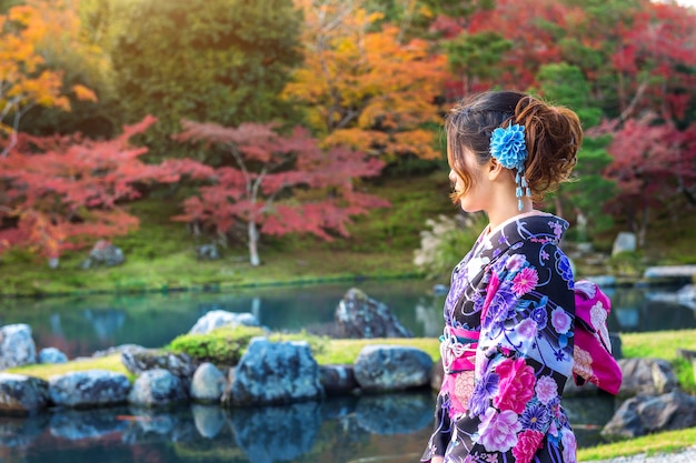 Asiatische frau, die traditionellen japanischen kimono im herbstpark trägt. japan