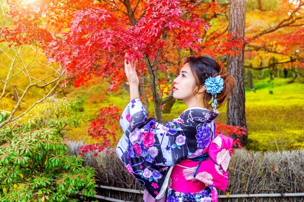 Asiatische Frau, die traditionellen japanischen Kimono im Herbstpark trägt. Japan