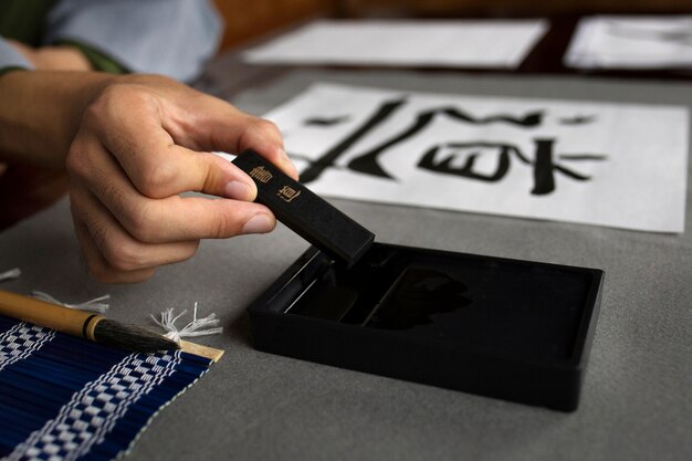 Asiatische Frau, die zuhause japanische Handschrift übt