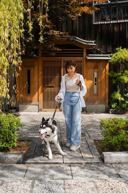 Kostenloses Foto asiatische frau geht mit ihrem husky-hund im freien spazieren