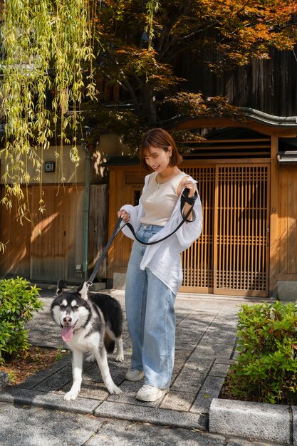 Asiatische Frau geht mit ihrem Husky-Hund im Freien spazieren