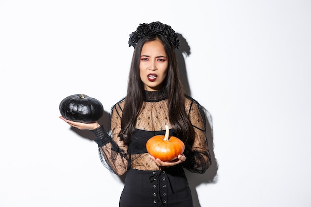 Asiatische Frau im Halloween-Kostüm, das aufwirft