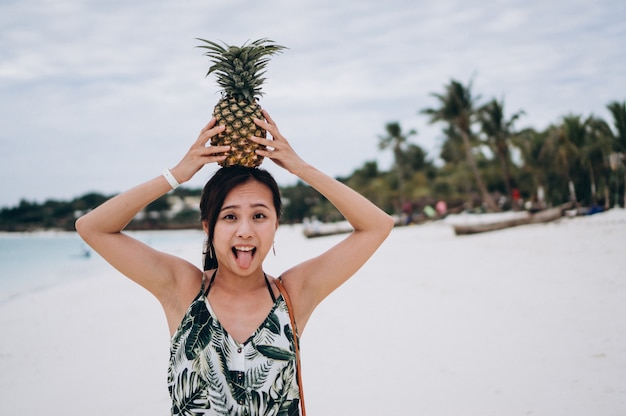 Kostenloses Foto asiatische frau mit ananas am strand