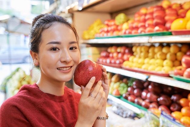 Asiatische Frau mit rotem Apfel