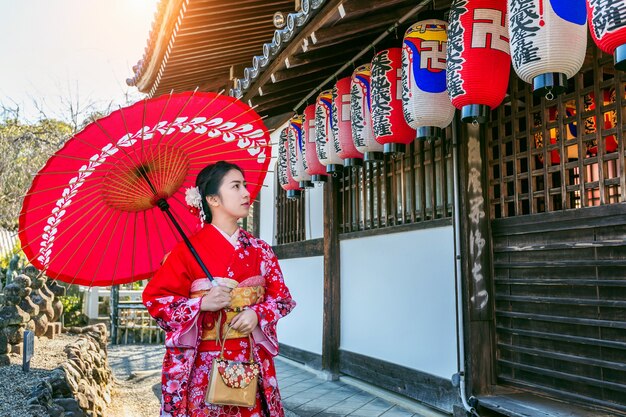 Asiatische Frauen, die japanischen traditionellen Kimono tragen, der das schöne in Kyoto besucht.